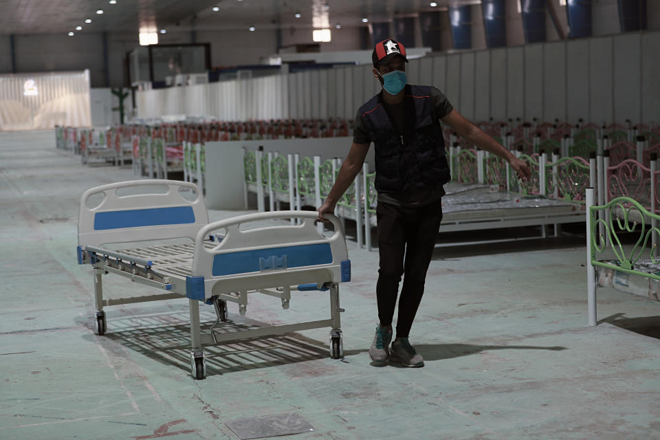 In this Saturday, June 20, 2020 photo, workers set up a field hospital to treat patients with COVID-19 in Baghdad, Iraq. New field hospitals have been erected to treat virus patients as hospitals reach capacity, but health workers fear the worst is still to come. (AP Photo/Hadi Mizban)