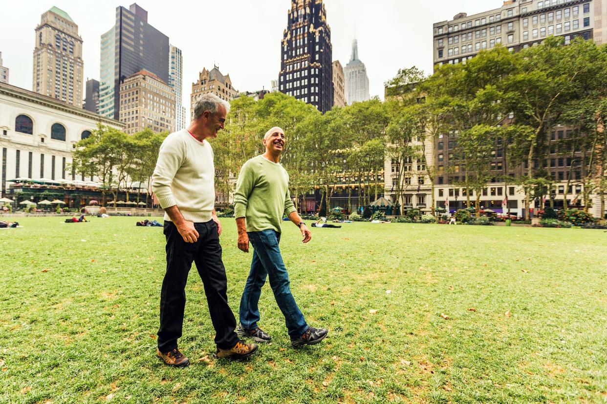 senior gay couple walking at park in New York