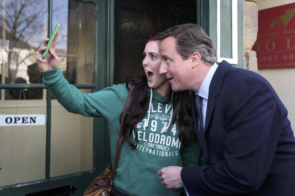 Britain's Prime Minister David Cameron poses for a selfie with a local woman as he campaigns in Alnwick