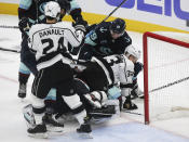 Los Angeles Kings left wing Viktor Arvidsson (33) reacts to being hit in the face by Seattle Kraken defenseman Vince Dunn (29) as Arvidsson falls on top of Seattle Kraken goaltender Chris Driedger (60) during the second period of an NHL hockey game, Saturday, Jan. 15, 2022, in Seattle. (AP Photo/Lindsey Wasson)