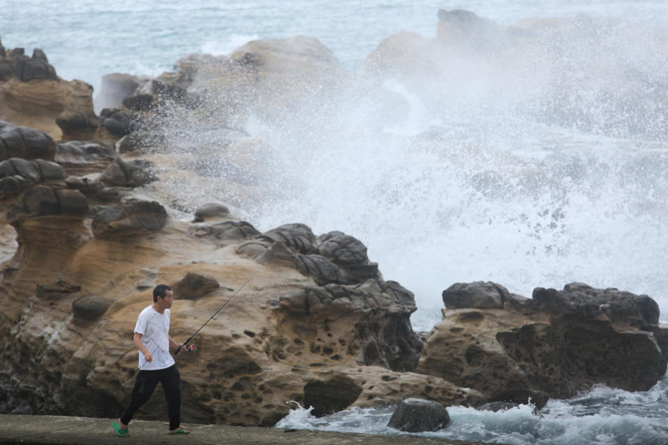 受颱風外流環流影響，東北角海浪日趨增強，仍有民眾不畏風雨在岸邊垂釣。（張鎧乙攝）