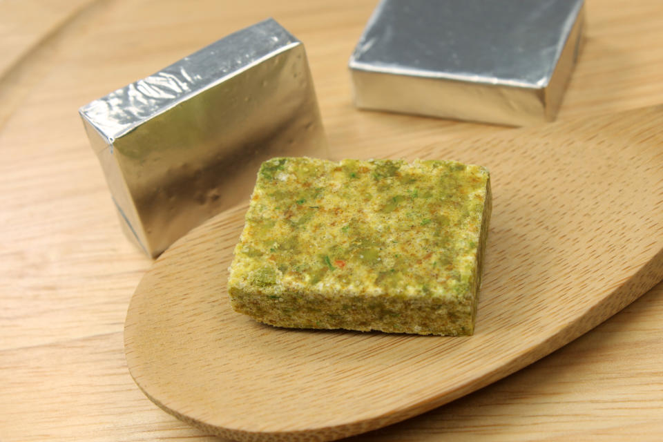 Bouillon cubes and wooden background