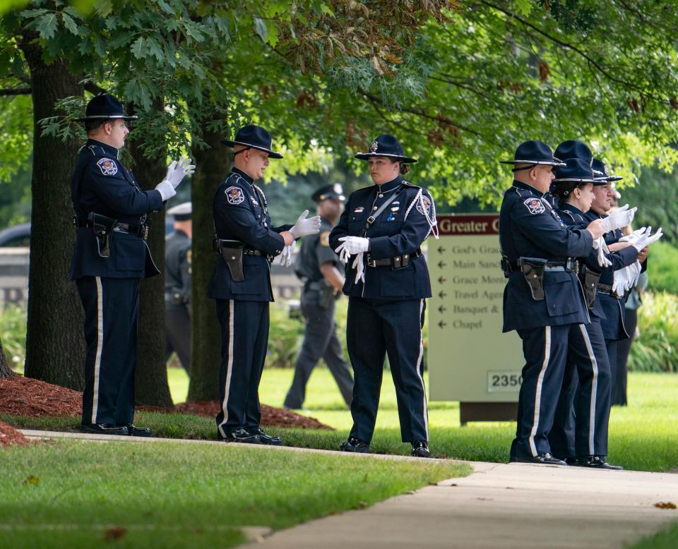 Members of Southfield Police Department don white gloves as they prepare outside of the Greater Grace Temple Monday, June 18, 2022, for the funeral of  fallen officer Loren Courts, who died in the line of duty. 