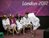 Dancers, wearing robes to keep themselves warm from the cold, wait outside the court before their performance at halftime at the London 2012 Olympic Games at Horse Guards Parade July 31, 2012. (REUTERS/Lucy Nicholson)