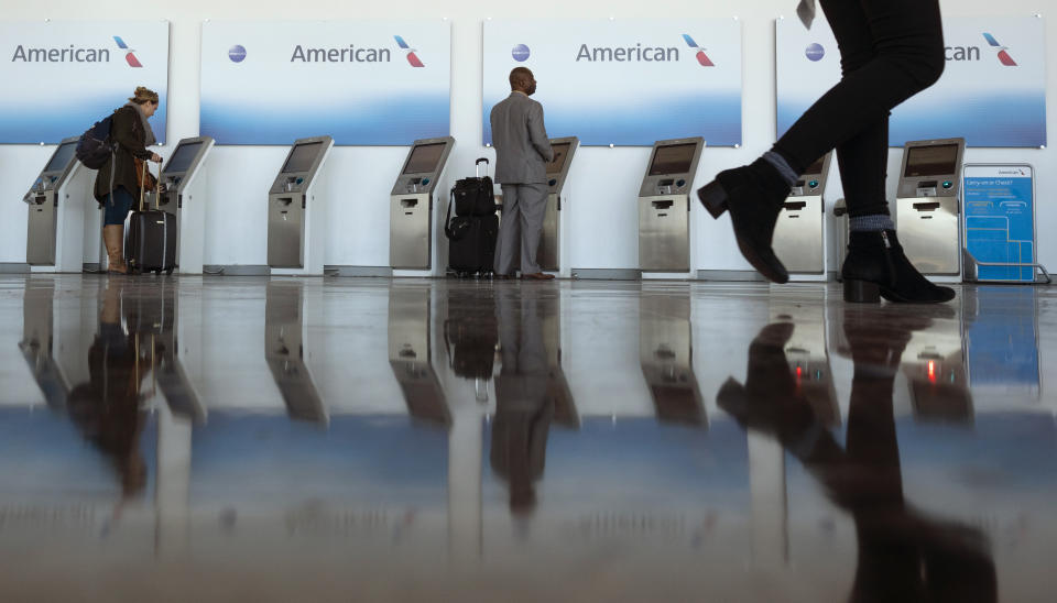 Travelers checkin in at American Airlines kiosks at Washington Reagan National Airport, Wednesday, Nov. 21, 2018, in Arlington, Va. The airline industry trade group Airlines for America expects that Wednesday will be the second busiest day of the holiday period behind only Sunday, when many travelers will be returning home after Thanksgiving. (AP Photo/Carolyn Kaster)