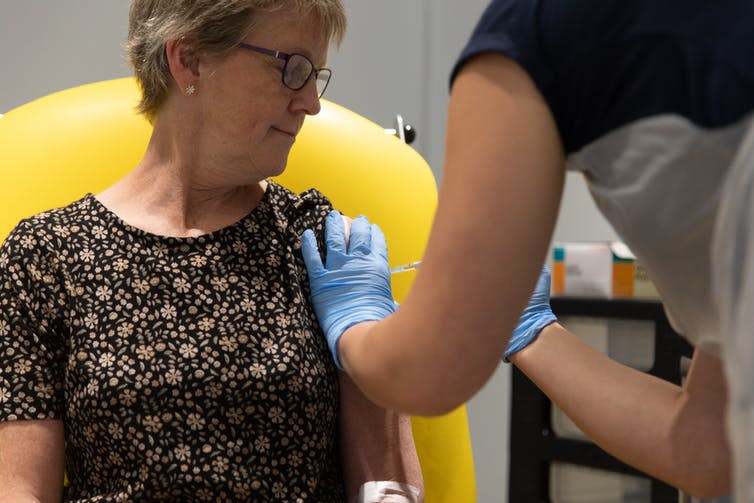 A nurse vaccinating a woman in her upper arm