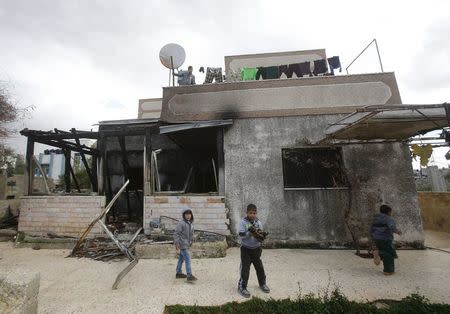 Palestinian boys play in the yard of the Dawabsheh family house at Duma village near the West Bank city of Nablus, December 3, 2015. REUTERS/Abed Omar Qusini