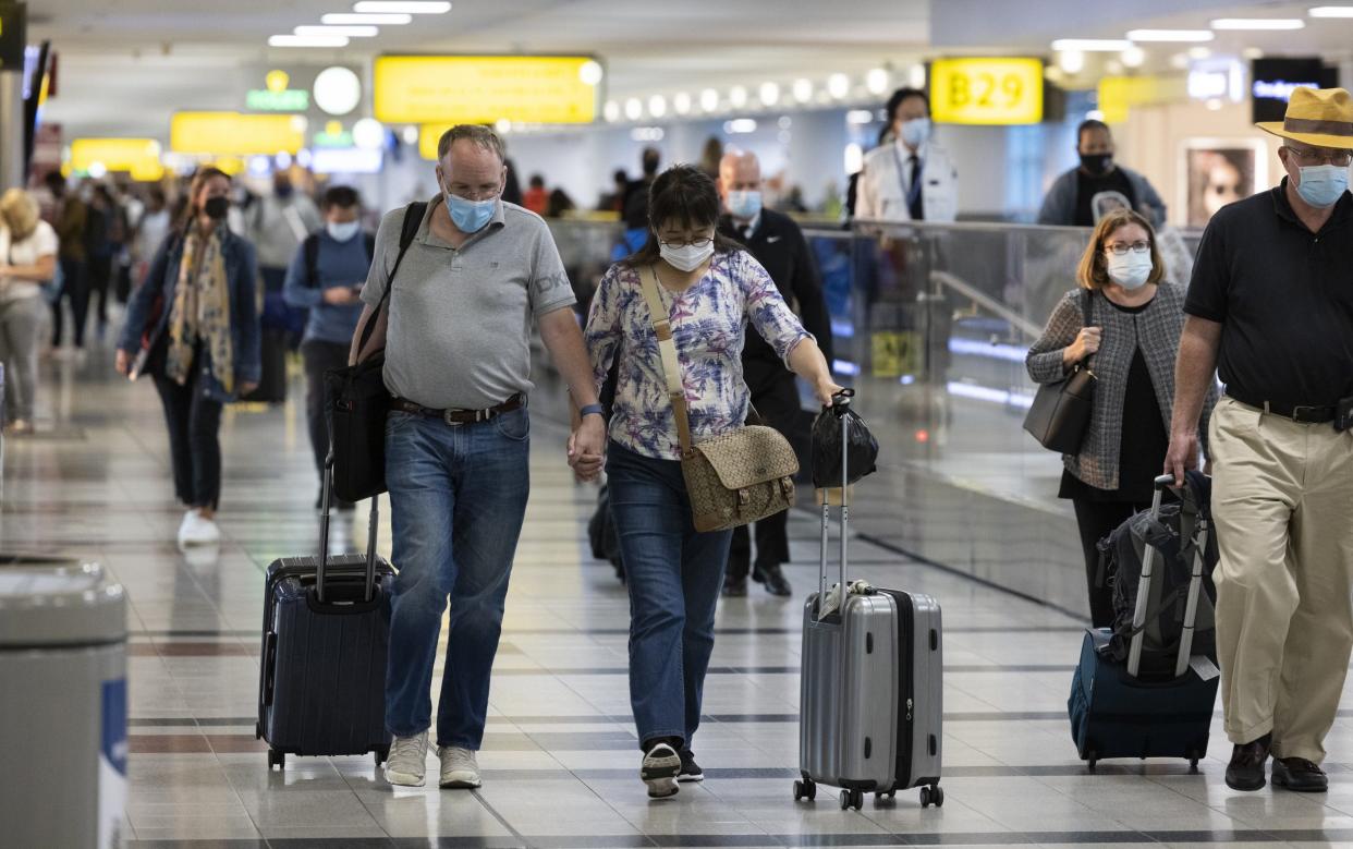 Travellers walk through John F. Kennedy International Airport - Angus Mordant/Bloomberg