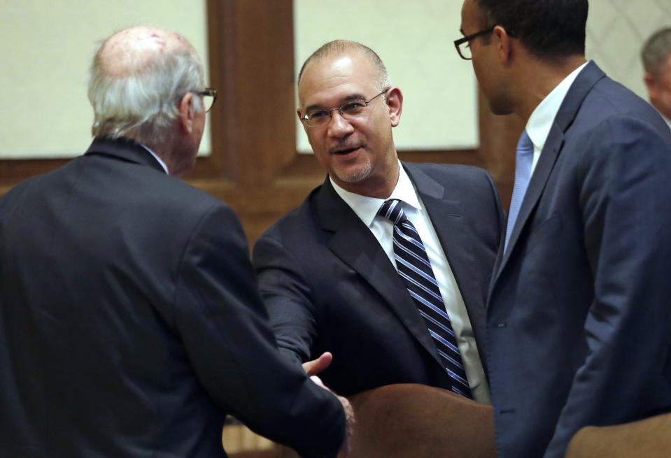 Bernard Dean, Chief Clerk of the House, shakes hands with Legislative attorneys following a hearing before the Washington Supreme Court Tuesday, June 11, 2019, in Olympia, Wash. The court heard oral arguments in the case that will determine whether state lawmakers are subject to the same disclosure rules that apply to other elected officials under the voter-approved Public Records Act. The hearing before the high court was an appeal of a case that was sparked by a September 2017 lawsuit filed by a media coalition, led by The Associated Press. (AP Photo/Elaine Thompson)
