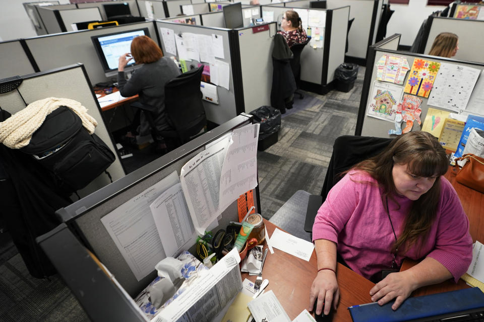 Workers field calls at an intake call screening center for the Allegheny County Children and Youth Services office in Penn Hills, Pa. on Thursday, Feb. 17, 2022. Incidents of potential neglect are reported to Allegheny County’s child protection hotline. The reports go through a screening process where the algorithm calculates the child’s potential risk and assigns it a score. Social workers then use their discretion to decide whether to investigate those concerns. (AP Photo/Keith Srakocic)