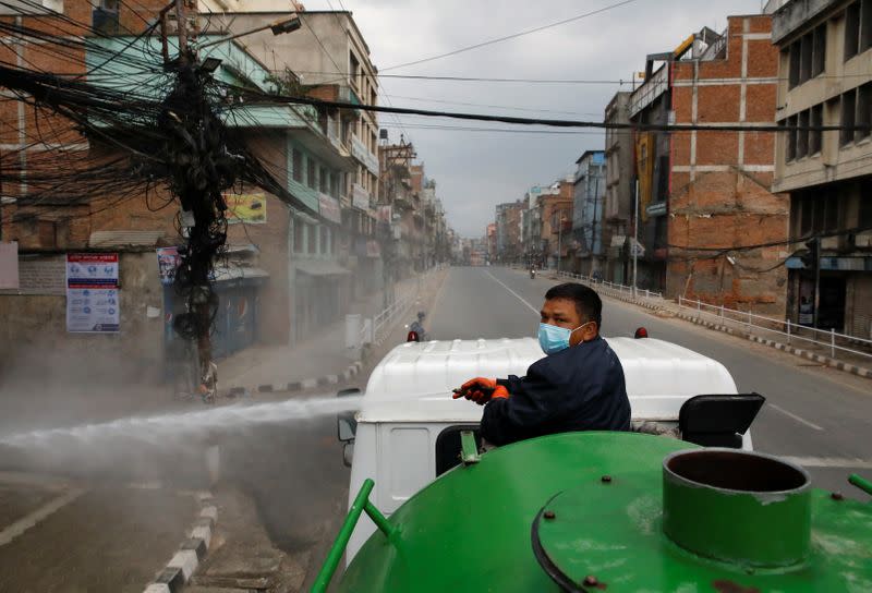 Worker sprays disinfectant on the street from a vehicle during the lockdown, in Kathmandu