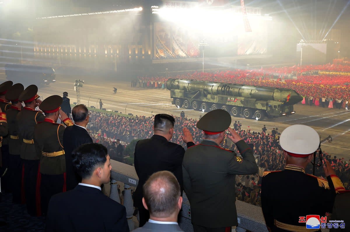 North Korea’s leader Kim Jong-n (C in black suit) watching as the new model of intercontinental ballistic missile (ICBM), the solid-fuel Hwasong-18, goes past in a military parade (KCNA VIA KNS/AFP via Getty Image)
