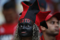 A woman, with the Portuguese word for "in mourning" painted on her forehead, waits for the start of a homage for the 10 teenage players killed by a fire at the Flamengo training center last Friday, at the Maracana Stadium, in Rio de Janeiro, Brazil, Thursday, Feb. 14, 2019, ahead of a soccer match between Flamengo and Fluminense. (AP Photo/Leo Correa)