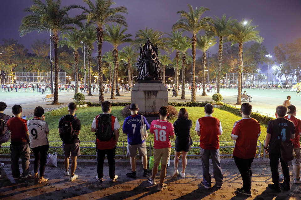Pro-democracy football fans gather to form a human chain near a bronze statue of Britain's Queen Victoria at Hong Kong's Victoria Park, Wednesday, Sept. 18, 2019. An annual fireworks display in Hong Kong marking China's National Day on Oct. 1 was called off Wednesday as pro-democracy protests show no sign of ending. (AP Photo/Kin Cheung)