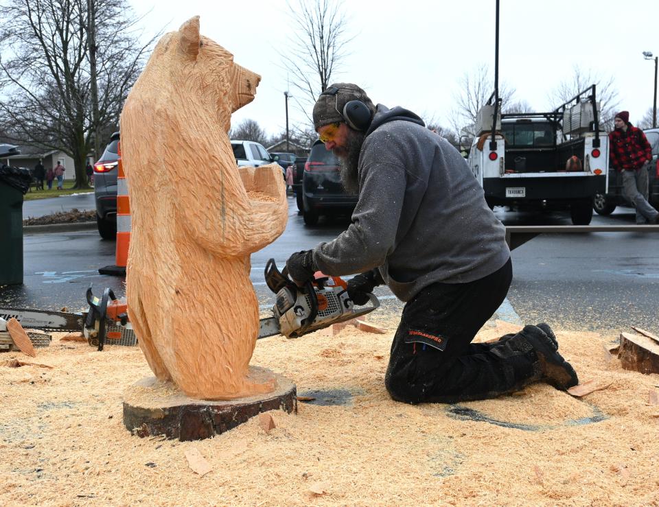 Scott Lepley rough cuts a bear from a pine log Saturday at Winterfest.