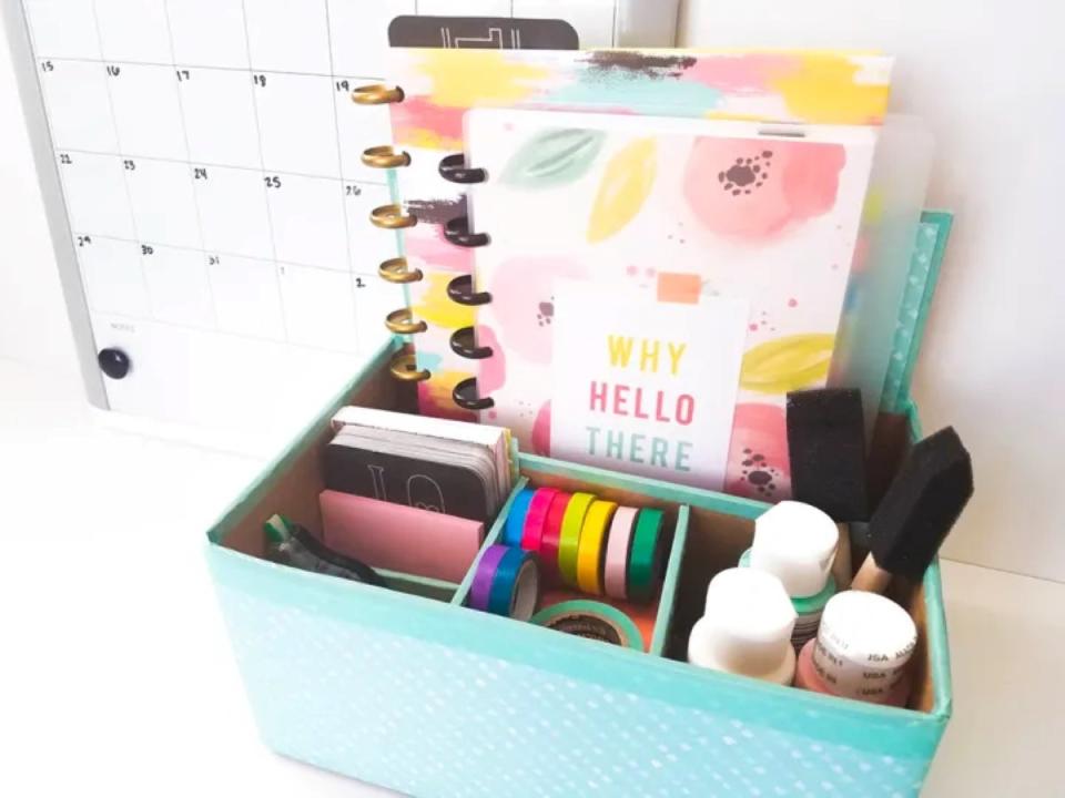 Desk organizer in four sections holding paint, ribbons, and notebooks.