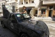 A member of "Free Men of Syria" (Ahrar Suriya) brigade, operating under the Free Syrian Army, washes a vehicle used by Free Syrian Army fighters in Aleppo's Bustan al-Qasr, September 9, 2013. REUTERS/Hamid Khatib