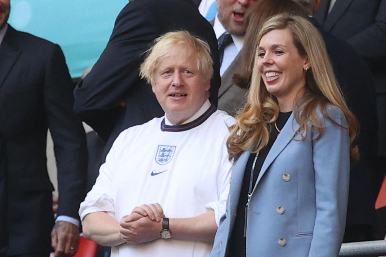 UK Prime Minister Boris Johnson and his spouse Carrie (R), are pictured ahead of the UEFA EURO 2020 semi-final football match between England and Denmark at Wembley Stadium in London on July 7, 2021. (Photo by CARL RECINE / POOL / AFP) (Photo by CARL RECINE/POOL/AFP via Getty Images)