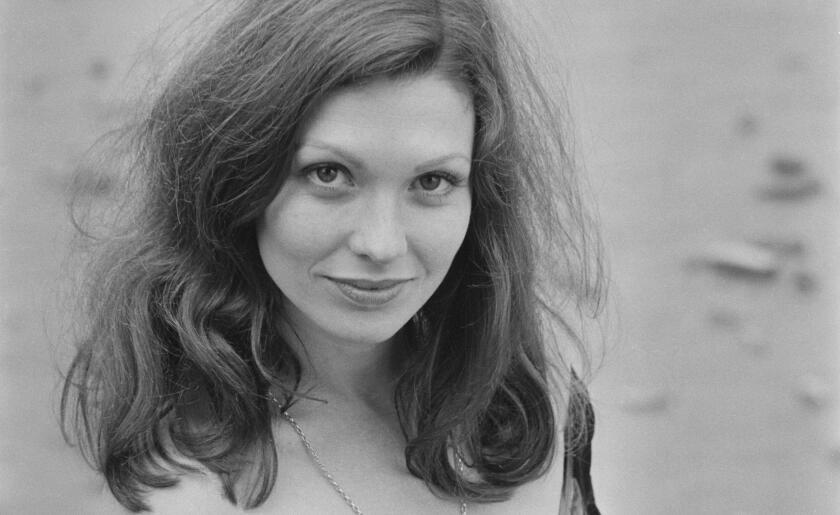 A black and white photo of a woman with long hair looking up