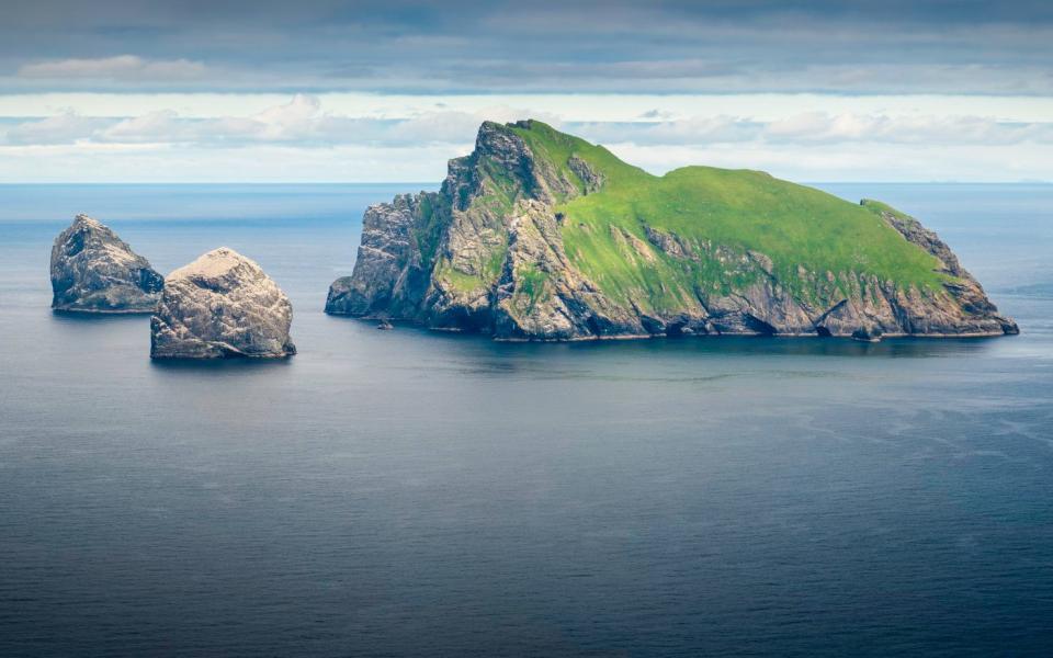 The precipitous rocky cliffs and steep green slopes of Boreray, the remote uninhabited island in the St. Kilda archipelago far off the western coast of the Outer Hebrides, Scotland