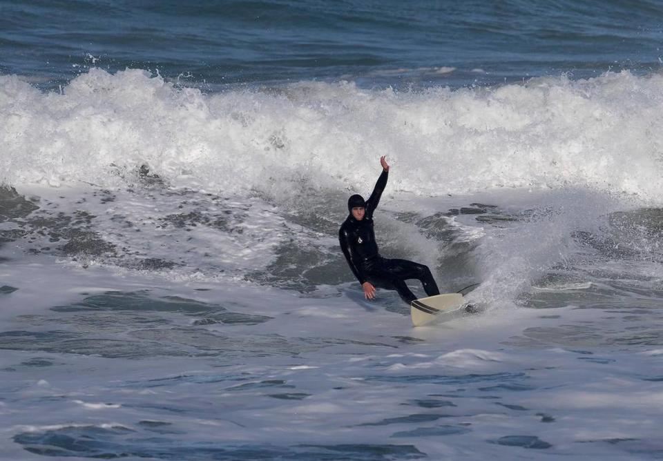 A lone surfer carves a wave near Morro Rock, Monday, Feb. 19, 2024, after a storm slammed San Luis Obispo County on Sunday night, bringing with it rising creeks and rivers and at least one swift water rescue.