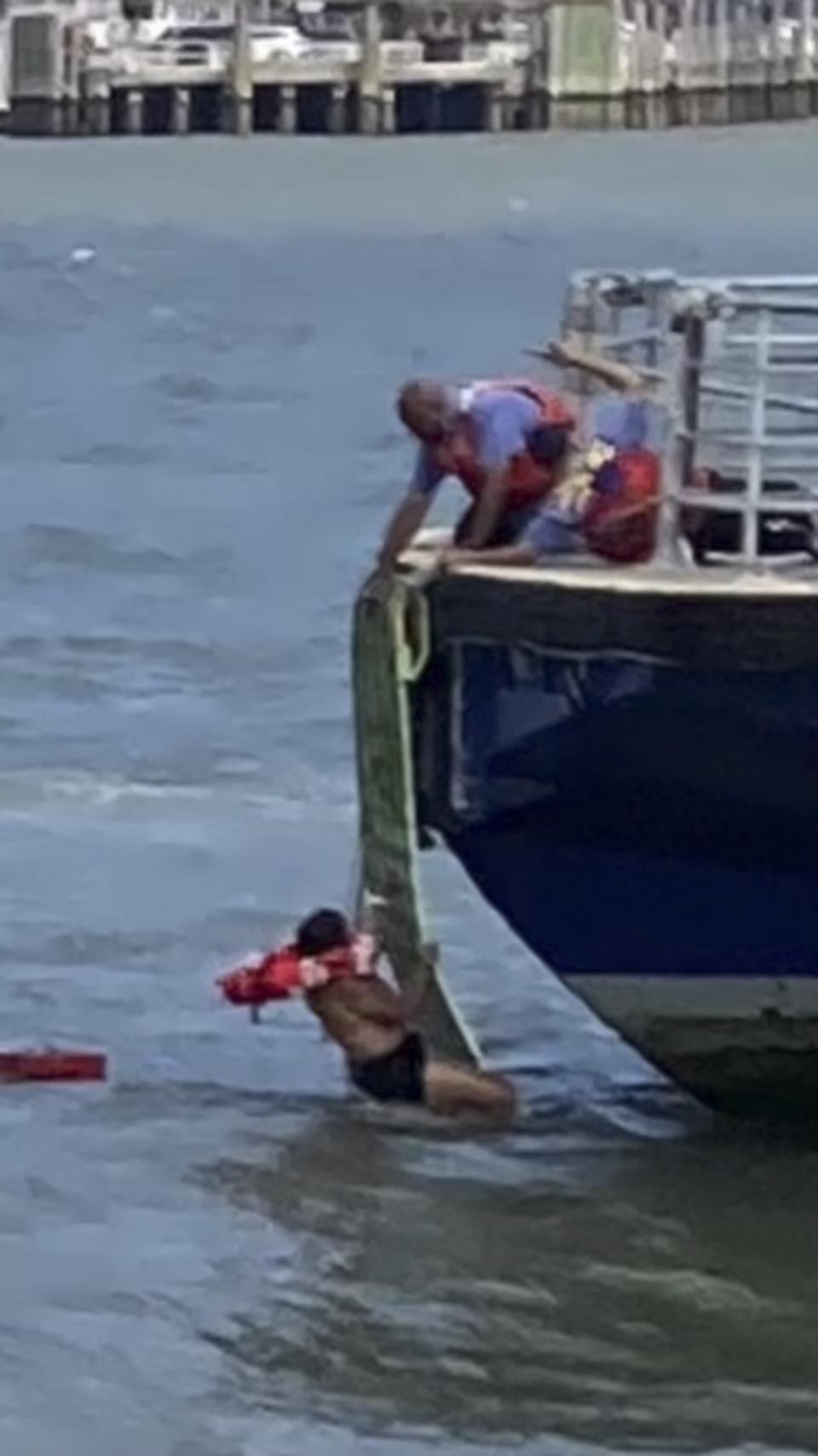 This photo provided by NY Waterway shows ferry personnel making rescue of individuals after a boat capsized in the Hudson River on Tuesday, July 12, 2022, in New York. (NY Waterway via AP)