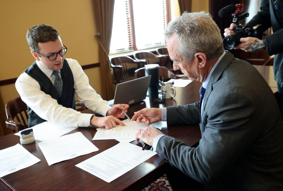 Brody Bailey, elections coordinator for the Office of the Utah Lieutenant Governor, assists independent presidential candidate Robert F. Kennedy Jr. as he files to get his name on the Utah ballot at the Capitol in Salt Lake City, on Wednesday, Jan. 3, 2024. | Kristin Murphy, Deseret News