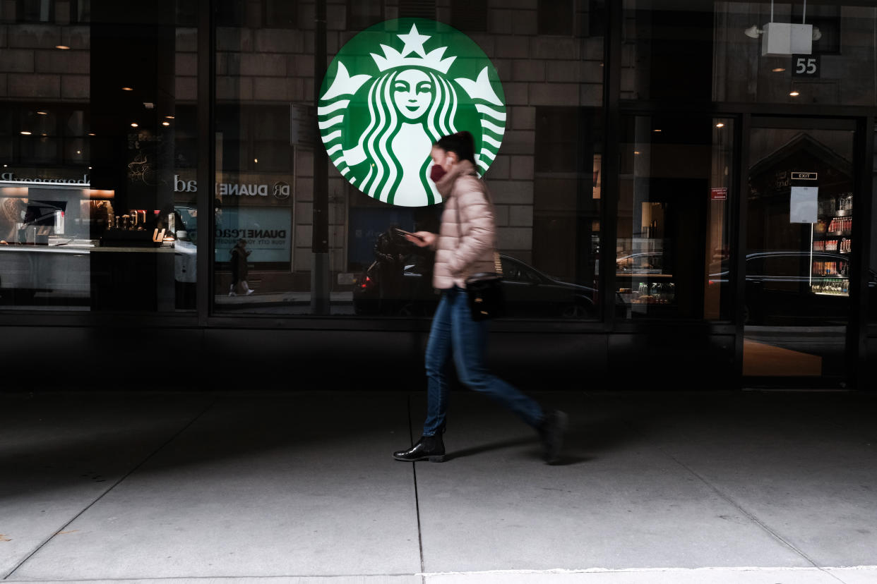 NEW YORK, NEW YORK - APRIL 04: A woman walks by a Starbucks coffee shop in Manhattan on April 04, 2022 in New York City. JPMorgan CEO Jamie Dimon has warned in his annual shareholder letter that continued inflation in the U.S. will lead to rising interest rates and will be one of the economic issues impacting the country's future.  (Photo by Spencer Platt/Getty Images)