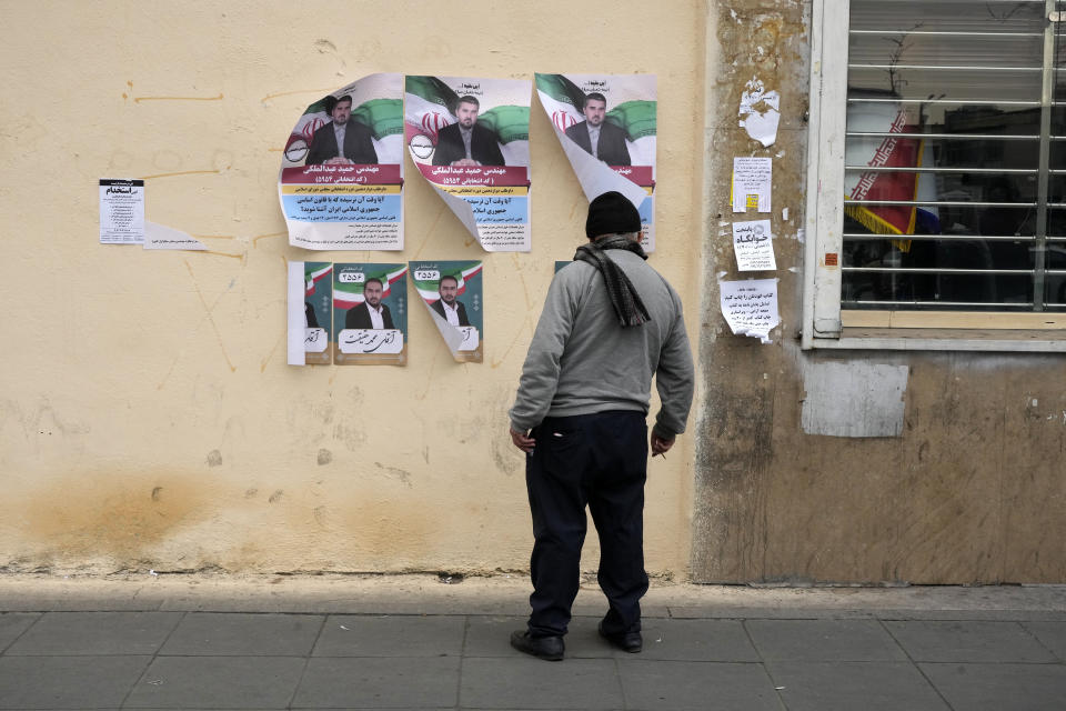 A man looks at electoral posters of candidates for the March 1, parliamentary election, in downtown Tehran, Iran, Thursday, Feb. 22, 2024. Candidates for Iran's parliament began campaigning Thursday in the country's first election since the bloody crackdown on the 2022 nationwide protests that followed the death of 22-year-old Mahsa Amini in police custody. (AP Photo/Vahid Salemi)