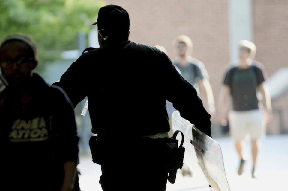 A University of North Carolina at Charlotte campus police officer carries a tactical shield after a shooting Tuesday afternoon, April 30, 2019, in Charlotte, N.C. The shooting on the campus left at least a few people dead and several wounded Tuesday, prompting a lockdown and chaotic scene in the state's largest city. (John Simmons/The Charlotte Observer via AP)