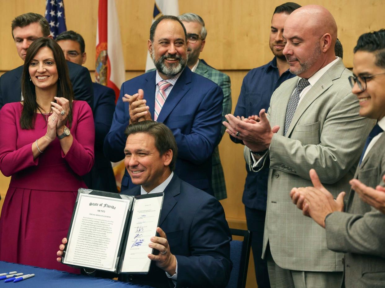 Florida Gov Ron DeSantis holds up signed legislation inside Florida International University’s MARC building in Miami on Monday, May 24, 2021. (AP)