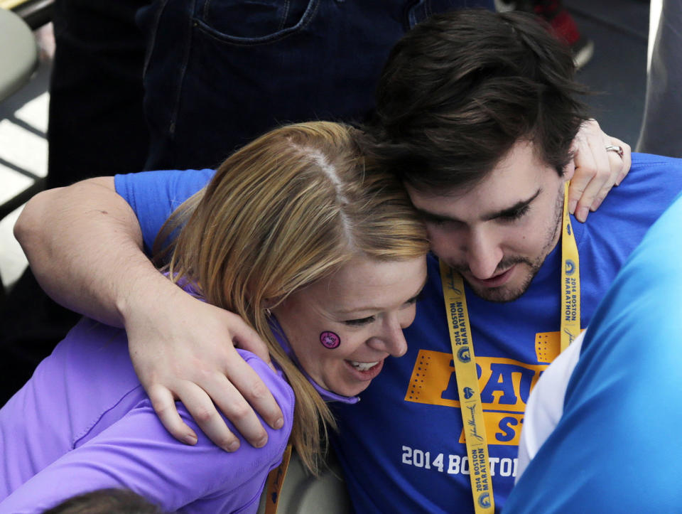 Boston Marathon bombings survivors Adrianne Haslet-Davis, left, and Jeff Bauman greet near the finish line of the 118th Boston Marathon, Monday, April 21, 2014, in Boston. (AP Photo/Charles Krupa)