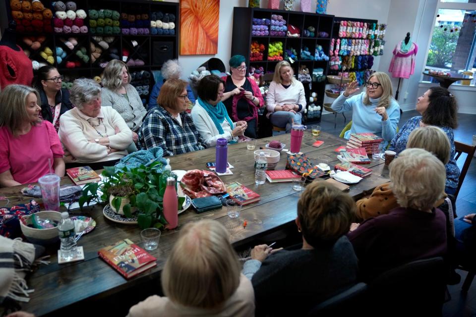 Ann Hood, at far right, tells a story about her TWA days during the "Reading With Robin" book event at Skein Yarn Shop in East Greenwich.