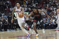 Philadelphia 76ers guard Kelly Oubre Jr. (9) dribbles the ball as Miami Heat forward Haywood Highsmith (24) defends during the first half of an NBA basketball game, Thursday, April 4, 2024, in Miami. (AP Photo/Marta Lavandier)