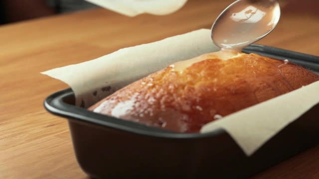 Glazing a lemon loaf cake with lemon glaze