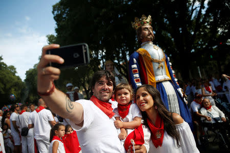 Sergio Colas takes a selfie with his wife Alma Sierra and their daughter Alaia as they take part in a procession in honour of San Fermin on the saint's day at the San Fermin festival in Pamplona, northern Spain, July 7, 2016. REUTERS/Susana Vera