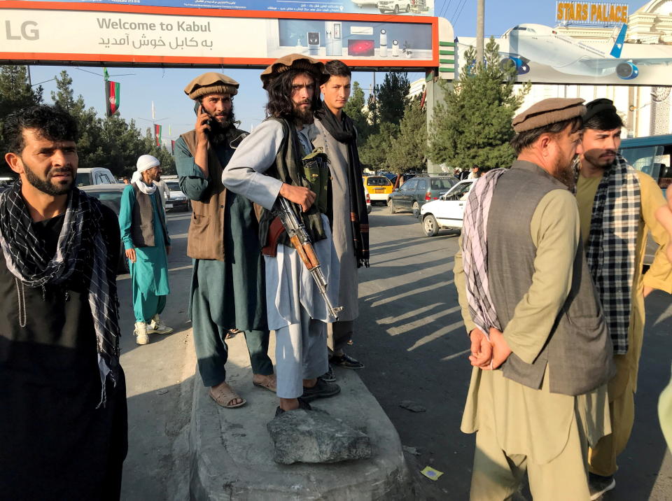 A member of Taliban (C) stands outside Hamid Karzai International Airport in Kabul, Afghanistan, August 16, 2021. REUTERS/Stringer REFILE - CORRECTING TO A MEMBER OF TALIBAN     TPX IMAGES OF THE DAY