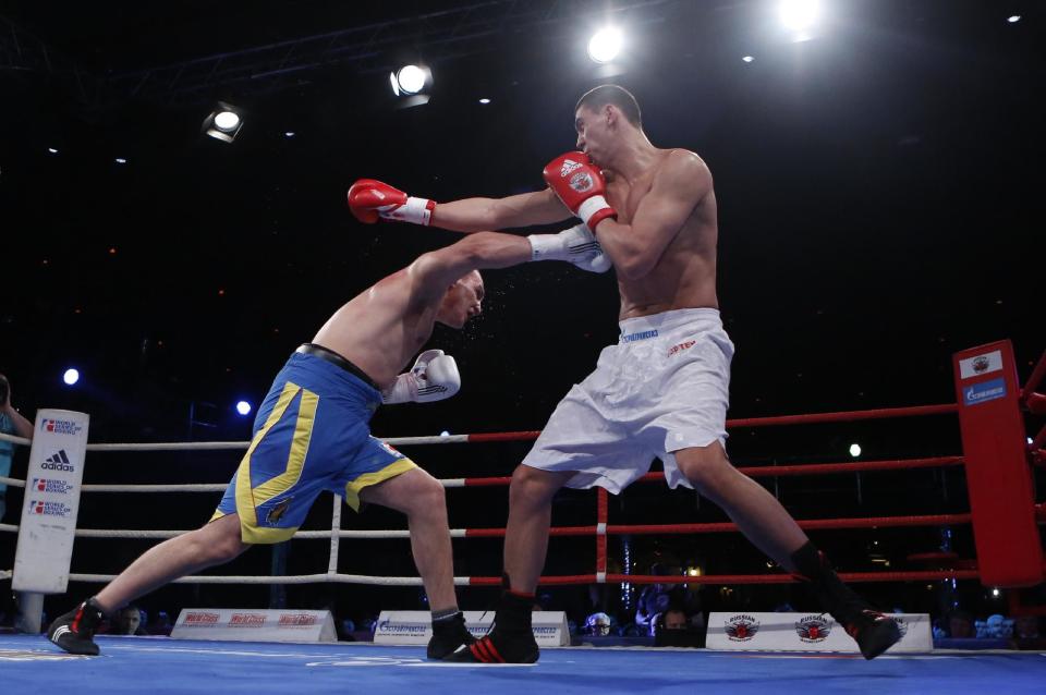 Ukraine's Sergei Korneev, left, in action with Russia's Yevgeny Tischenko during their heavyweight 91-kg World Series of Boxing quarterfinal bout between Russian Boxing Team and Ukraine Otamans, in Moscow, Russia, Monday, March, 31, 2014. Second leg matches will take part in Donetsk, Ukraine, on April 4. (AP Photo/Denis Tyrin)