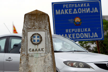 A car travels past a Greek border stone and a sign of Republic of Macedonia at the Macedonia-Greece border April 16, 2018. Picture taken April 16, 2018. REUTERS/Ognen Teofilovski/Files