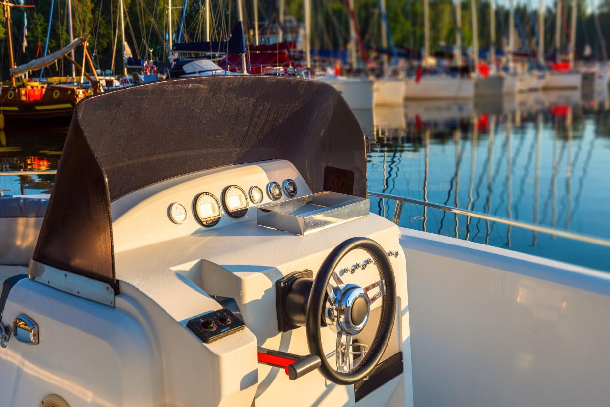 Instrument panel, navigation implement and steering wheel of a motor boat cockpit. Horizontal shot