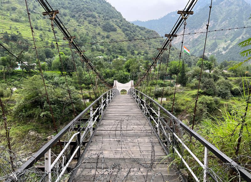 FILE PHOTO: A general view of a bridge between Pakistan and India, closed since 2018, with an Indian flag in the background, in Chilehana