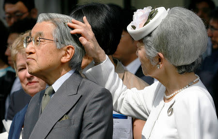 FILE PHOTO : Empress Michiko tries to get a bee out of the hair of Japan's Emperor Akihito during a tour at the Institute of Ocean Sciences in Victoria, British Columbia, July 12, 2009. REUTERS/Todd Korol/File Photo