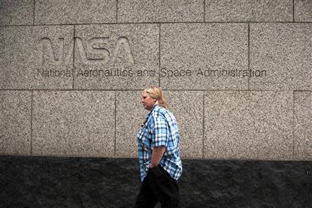 A woman walks past the NASA headquarters on Tuesday morning after the federal government was shutdown when the House and Senate failed to pass a budget in Washington October 1, 2013. REUTERS/James Lawler Duggan