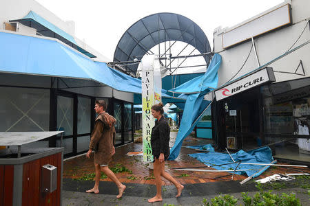 People walk past damaged shops after Cyclone Debbie hit the northern Queensland town of Airlie Beach, located south of Townsville in Australia, March 29, 2017. AAP/Dan Peled/via REUTERS