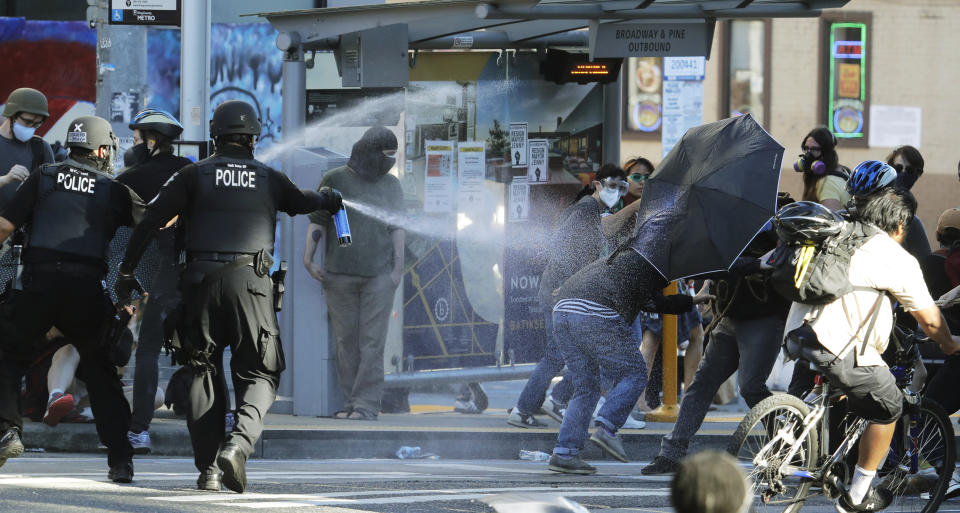 FILE - Police pepper spray protesters near Seattle Central College in Seattle, July 25, 2020, during a march and protest in support of Black Lives Matter. The U.S. Justice Department and Seattle officials on Tuesday, March 28, 2023, asked a judge to end most federal oversight of the city's police department, saying its sustained, decade-long reform efforts are a model for cities around the country whose law enforcement agencies face federal civil rights investigations. (AP Photo/Ted S. Warren, File)