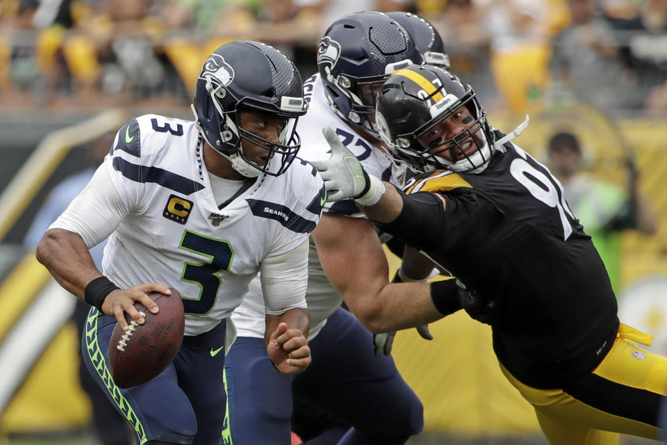 Seattle Seahawks quarterback Russell Wilson (3) scrambles past Pittsburgh Steelers defensive end Cameron Heyward (97), who is blocked by Seahawks offensive guard Ethan Pocic (77) during the second half of an NFL football game in Pittsburgh, Sunday, Sept. 15, 2019. The Seahawks won 28-26. (AP Photo/Gene J. Puskar)
