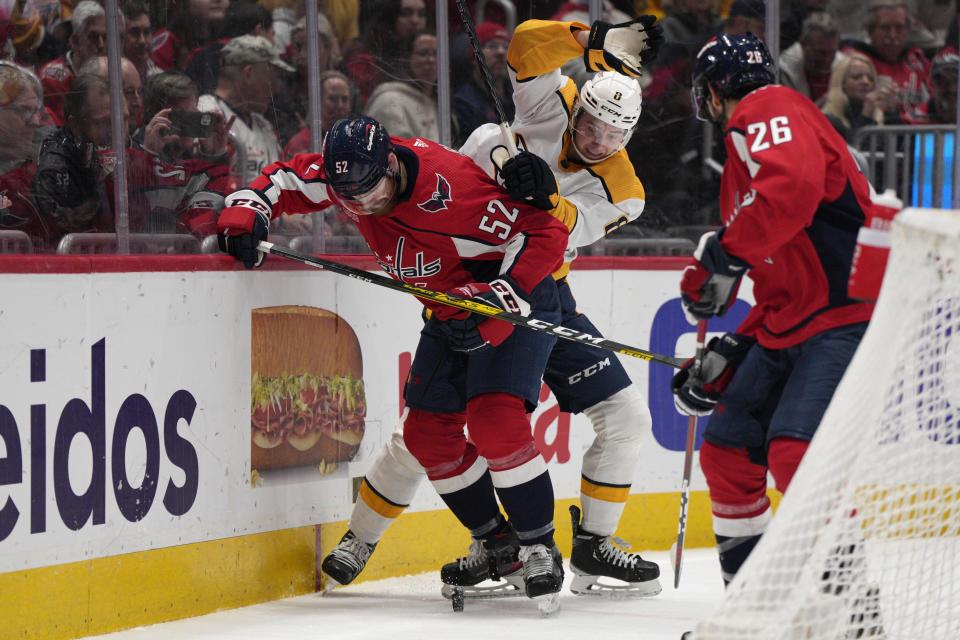 Washington Capitals defenseman Matt Irwin (52) and Nashville Predators center Cody Glass (8) work behind the goal during the second period of an NHL hockey game, Friday, Jan. 6, 2023, in Washington. (AP Photo/Jess Rapfogel)