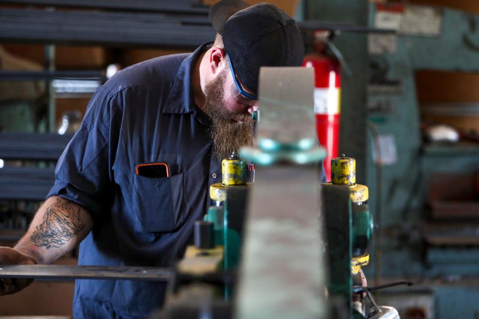 Frank Haar guides metal strips through a hydraulic machine called the “Piranha” that will cut holes out of the metal at Lui Heimansohn New Steel in Clarksville, Tenn., on Wednesday, Oct. 7, 2020.