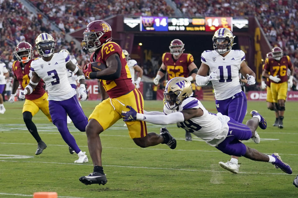 Southern California running back Darwin Barlow (22) is tackled by Washington safety Vincent Nunley (28) during the first half of an NCAA college football game Saturday, Nov. 4, 2023, in Los Angeles. (AP Photo/Marcio Jose Sanchez)