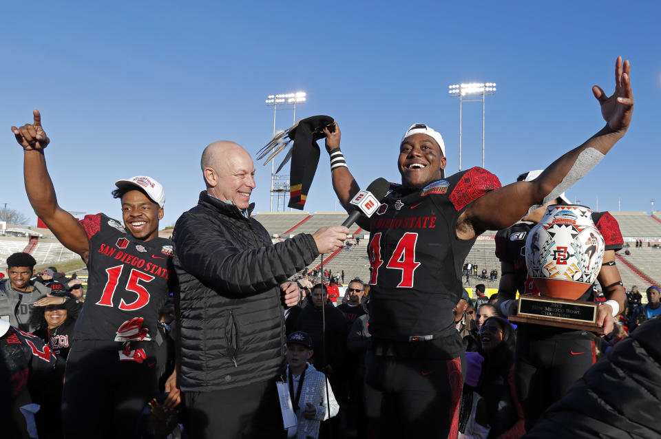 San Diego State linebacker Kyahva Tezino (44), recipient of the defensive MVP award, and running back Jordan Byrd (15), offensive MVP, celebrate after their team beat Central Michigan in the New Mexico Bowl NCAA college football game on Saturday, Dec. 21, 2019 in Albuquerque, N.M. (AP Photo/Andres Leighton)